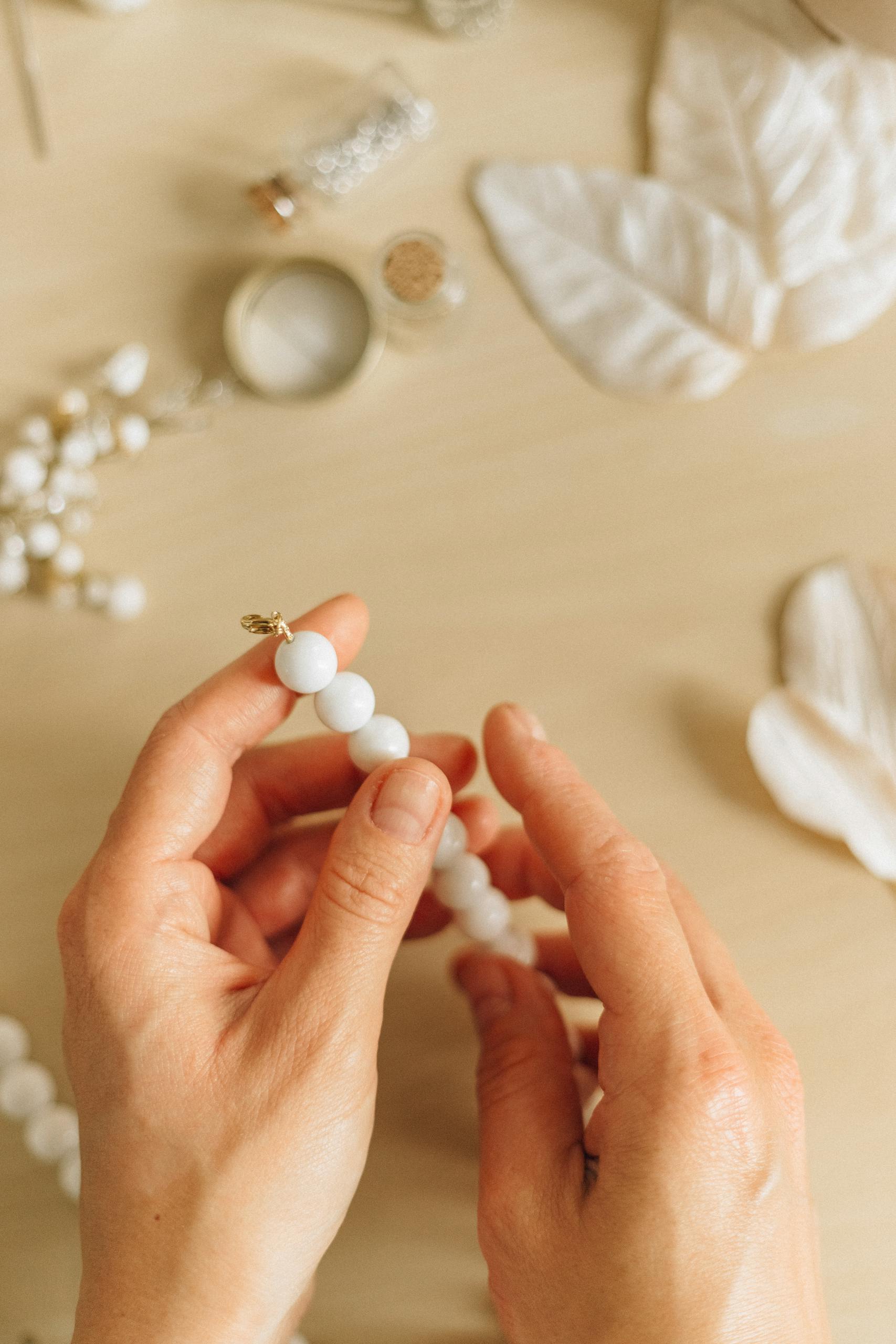 Person Holding White Pearl Beads